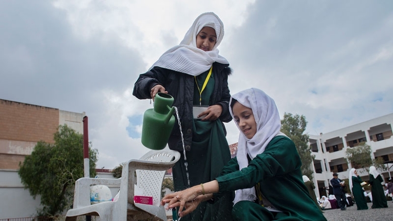 Des jeunes filles utilisant de l'eau pour se laver les mains au Yémen.